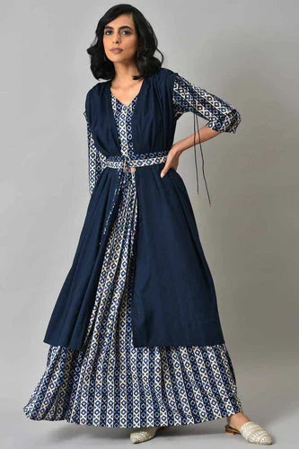 Woman wearing a navy co-ord set with a patterned dress and long outer layer